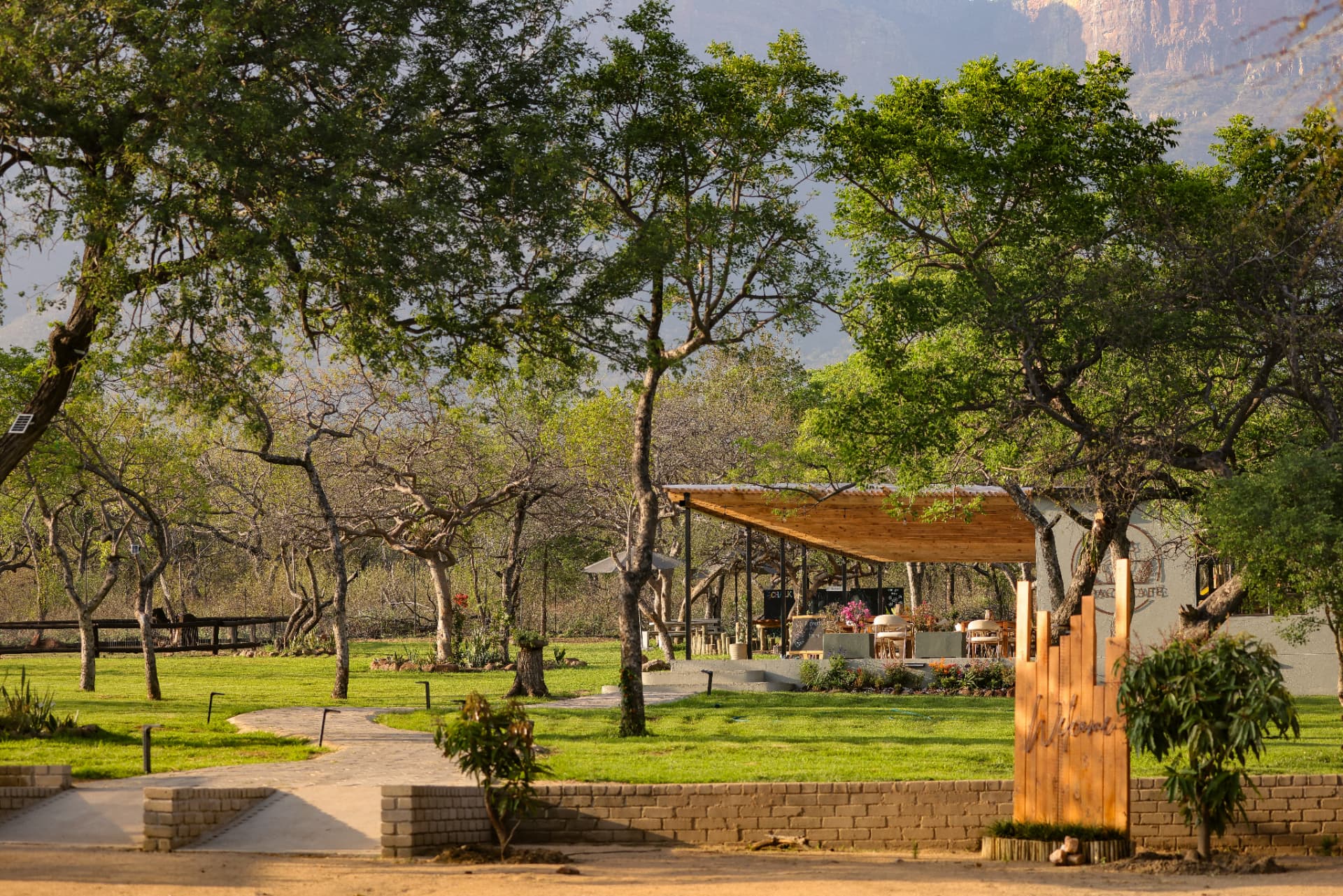 Alpaca Cafe lawn and shaded patio on the farm, with the mountains rising behind